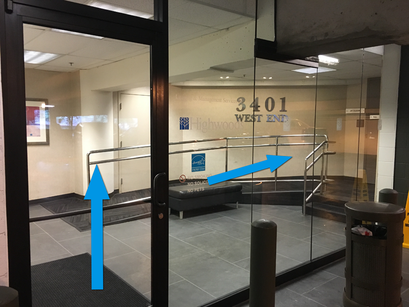 The entrance to the building, which opens to the third floor, is through the glass door inside the parking garage. 